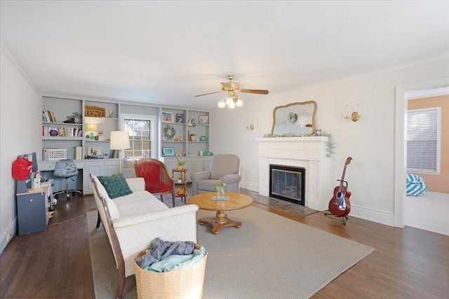 living area featuring a fireplace with flush hearth, baseboards, wood finished floors, and ornamental molding