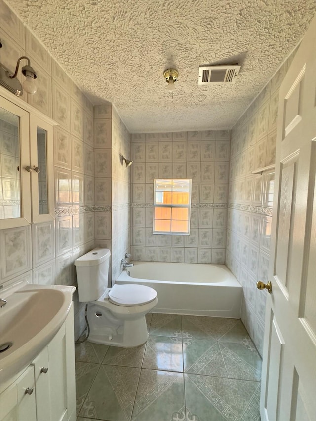 full bathroom with visible vents, toilet, a textured ceiling, vanity, and shower / washtub combination