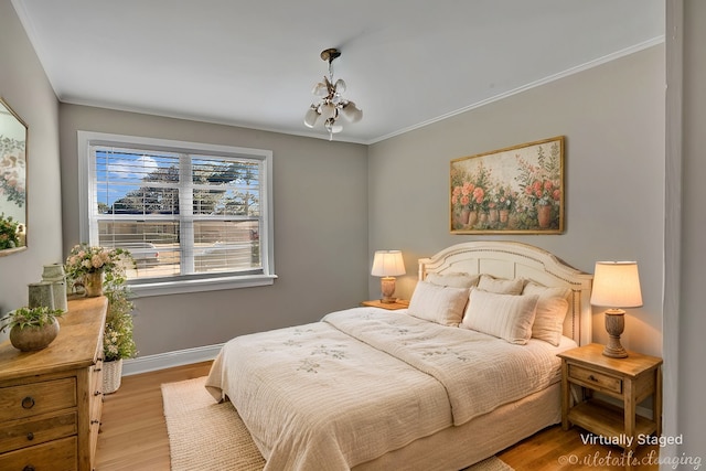 bedroom with baseboards, ornamental molding, wood finished floors, and a notable chandelier