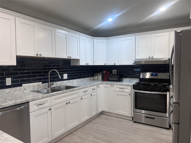 kitchen with appliances with stainless steel finishes, a sink, white cabinets, and under cabinet range hood