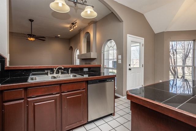 kitchen featuring light tile patterned floors, a ceiling fan, dishwasher, vaulted ceiling, and a sink