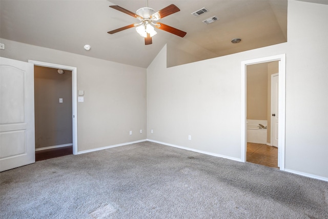 spare room featuring a ceiling fan, carpet flooring, vaulted ceiling, and visible vents