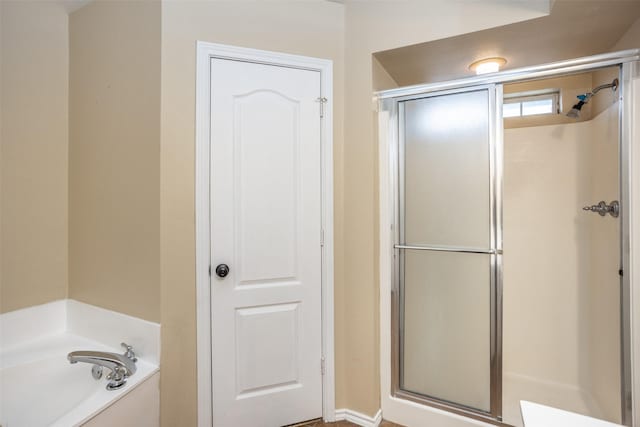 bathroom featuring a stall shower and a garden tub