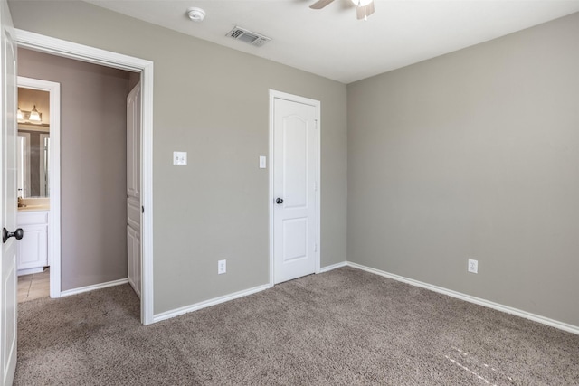 unfurnished bedroom with carpet, visible vents, baseboards, and ensuite bathroom