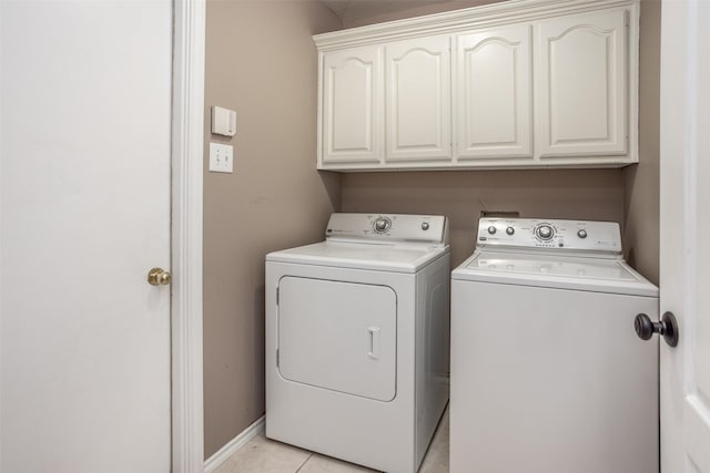 washroom with cabinet space, washer and clothes dryer, and light tile patterned floors