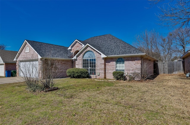 ranch-style home with a garage, brick siding, roof with shingles, and a front yard