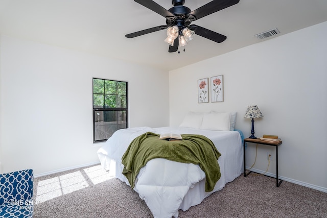 carpeted bedroom featuring a ceiling fan, visible vents, and baseboards