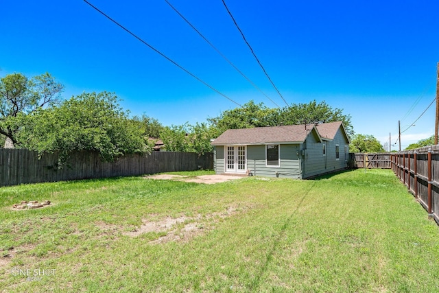 view of yard with a fenced backyard and french doors