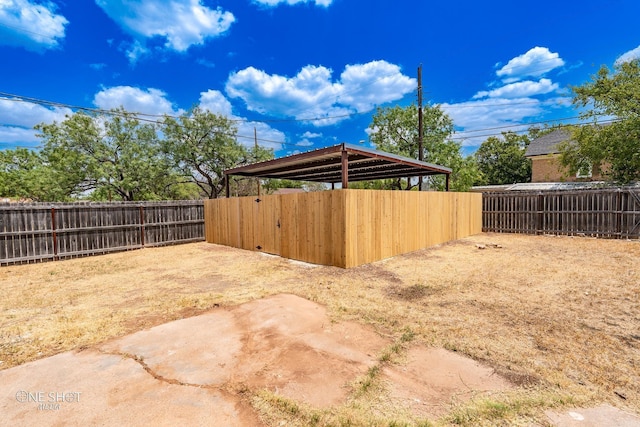 view of yard with a fenced backyard and a detached carport