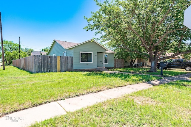 view of front of house with a front yard and fence