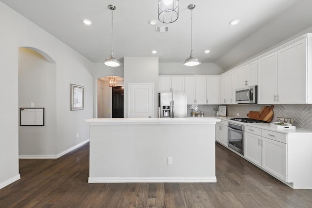 kitchen featuring visible vents, arched walkways, white cabinets, appliances with stainless steel finishes, and backsplash