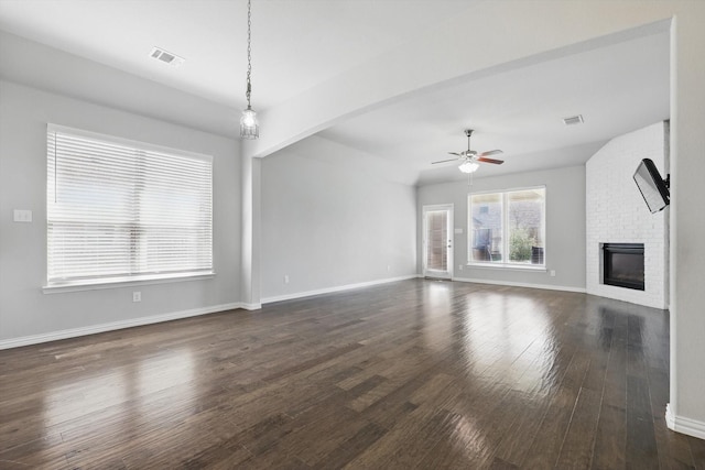 unfurnished living room with visible vents, baseboards, ceiling fan, dark wood finished floors, and a fireplace