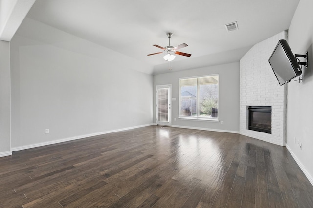 unfurnished living room featuring dark wood finished floors, a fireplace, baseboards, visible vents, and a ceiling fan