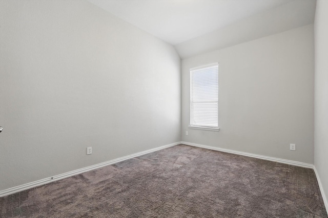 spare room with lofted ceiling, carpet flooring, and baseboards