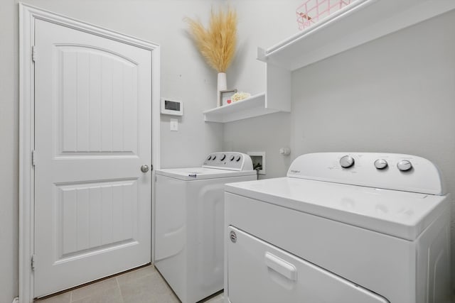 washroom featuring light tile patterned floors, laundry area, and washer and clothes dryer