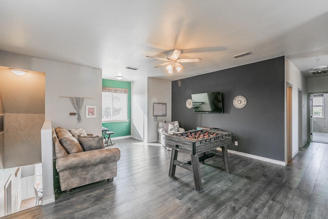 recreation room featuring dark wood-style flooring, visible vents, and baseboards