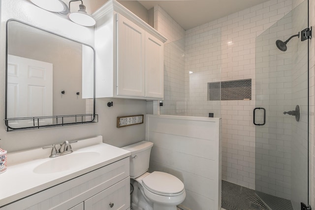 full bath featuring vanity, a shower stall, and toilet