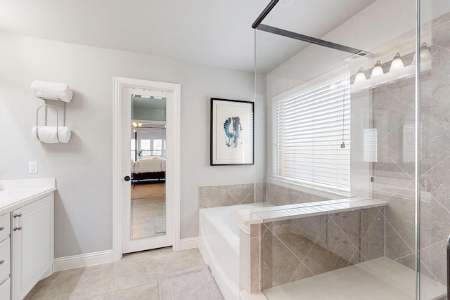 bathroom with baseboards, ensuite bath, a tile shower, vanity, and a bath