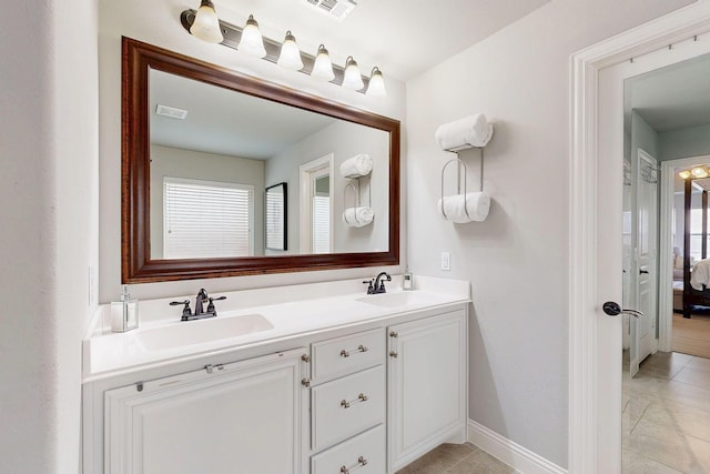 ensuite bathroom with double vanity, ensuite bath, visible vents, and a sink