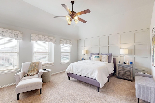 bedroom featuring a ceiling fan, light colored carpet, a decorative wall, and baseboards