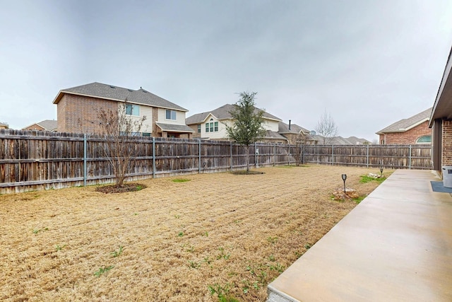 view of yard with a fenced backyard and a residential view