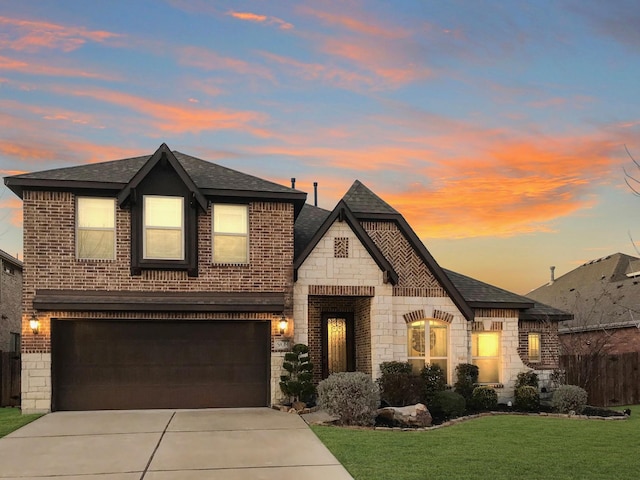 view of front of house featuring stone siding, brick siding, a lawn, and concrete driveway