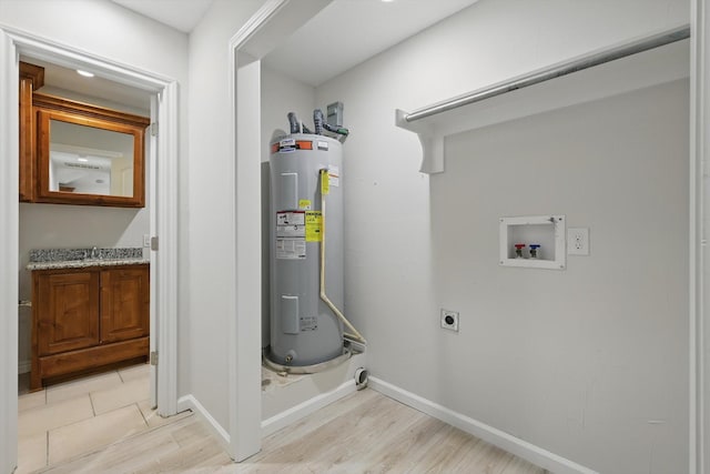 utility room with water heater and a sink