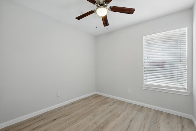 spare room with ceiling fan, light wood finished floors, and baseboards