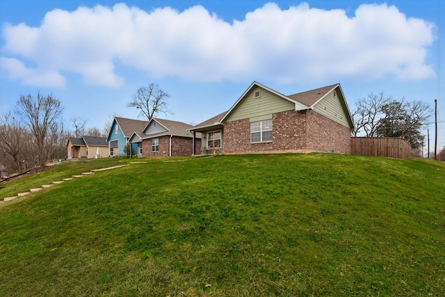 exterior space featuring a yard and brick siding