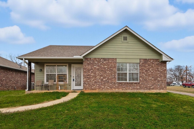 single story home featuring roof with shingles, brick siding, a front lawn, and a porch