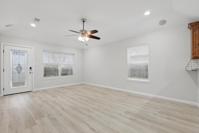 unfurnished room with light wood finished floors, visible vents, baseboards, and a ceiling fan