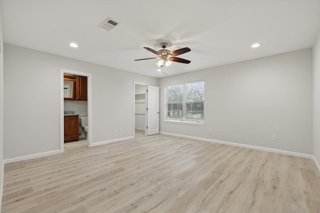 empty room featuring visible vents, ceiling fan, light wood-style flooring, and baseboards