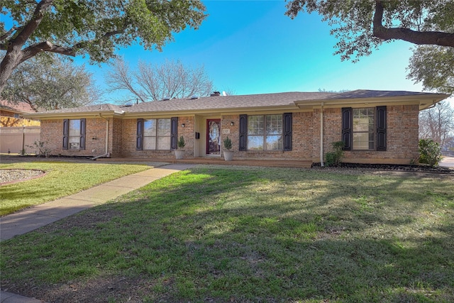 ranch-style home featuring a front lawn and brick siding