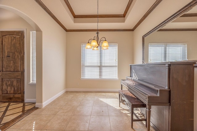 foyer entrance featuring arched walkways, light tile patterned floors, a raised ceiling, ornamental molding, and baseboards