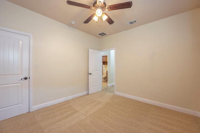 spare room with light colored carpet, visible vents, and baseboards