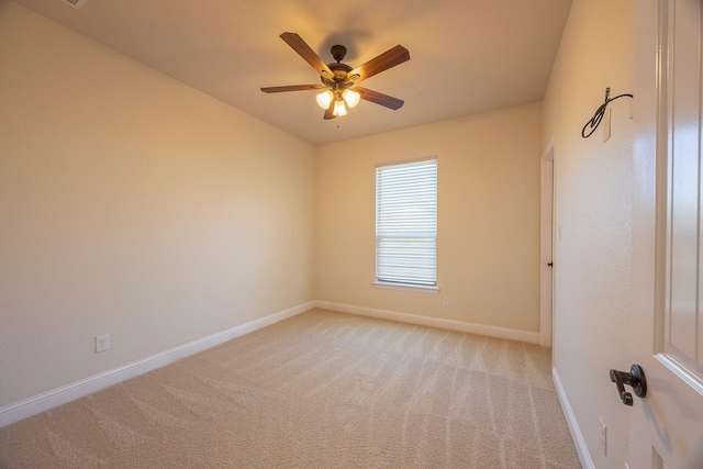 unfurnished room featuring a ceiling fan, light colored carpet, and baseboards