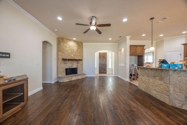 living room featuring a fireplace, visible vents, wood finished floors, and ornamental molding