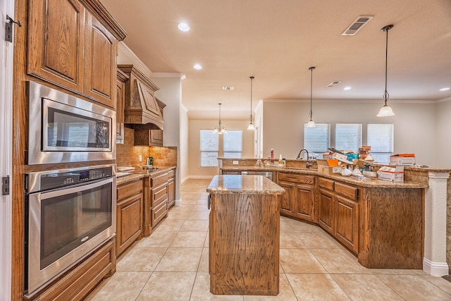 kitchen featuring light tile patterned floors, stainless steel appliances, visible vents, a center island, and crown molding