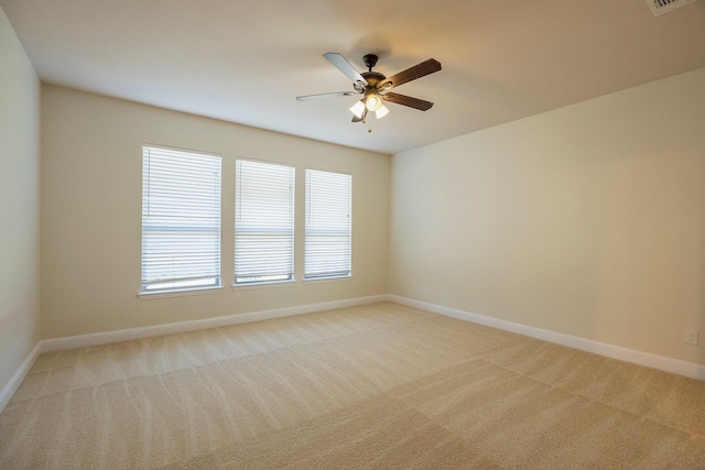 empty room featuring baseboards, a ceiling fan, and light colored carpet