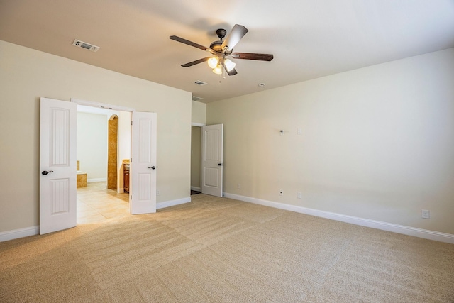 unfurnished bedroom with light colored carpet, visible vents, connected bathroom, and baseboards