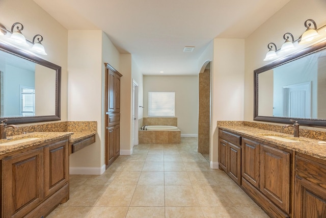 bathroom with tile patterned flooring, two vanities, a sink, and a bath