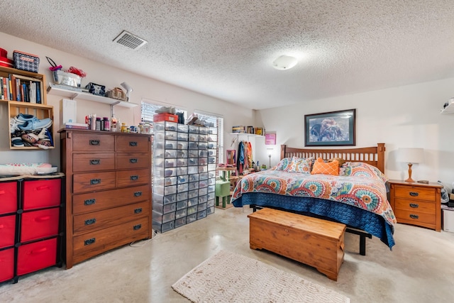 bedroom featuring a textured ceiling, concrete floors, and visible vents