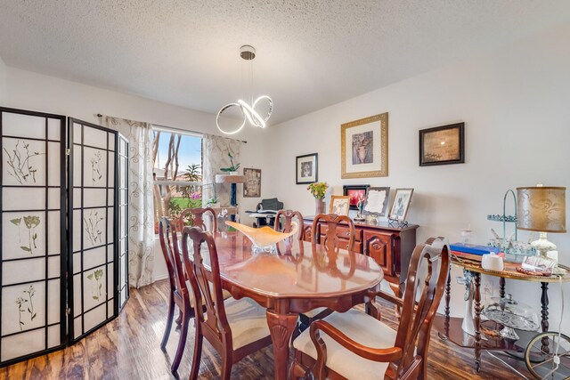 dining room featuring visible vents, plenty of natural light, a textured ceiling, and wood finished floors