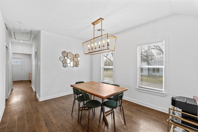 dining area with attic access, dark wood-style flooring, vaulted ceiling, and baseboards