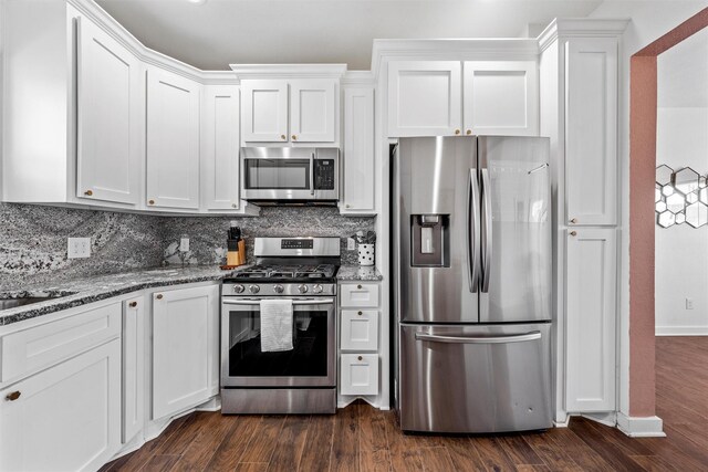 kitchen featuring white cabinetry, appliances with stainless steel finishes, tasteful backsplash, and dark wood-style flooring