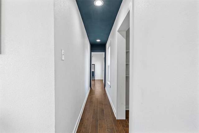 hallway with dark wood-type flooring, recessed lighting, and baseboards