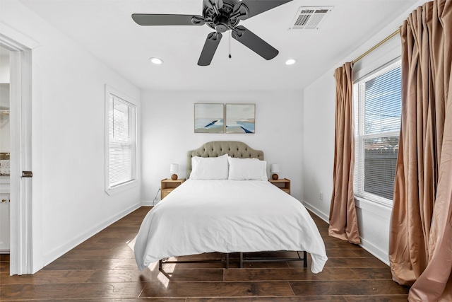 bedroom featuring multiple windows, wood finished floors, visible vents, and baseboards