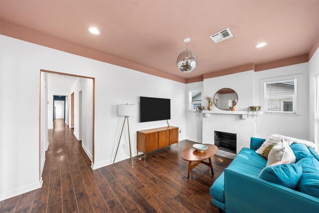 living area with a fireplace, recessed lighting, visible vents, wood finished floors, and baseboards