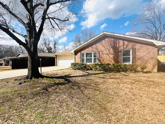 view of front facade with concrete driveway, brick siding, and an attached garage