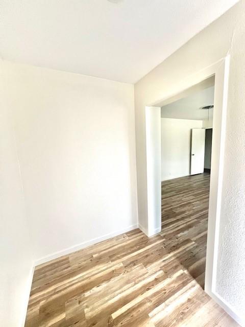 empty room featuring baseboards and wood finished floors